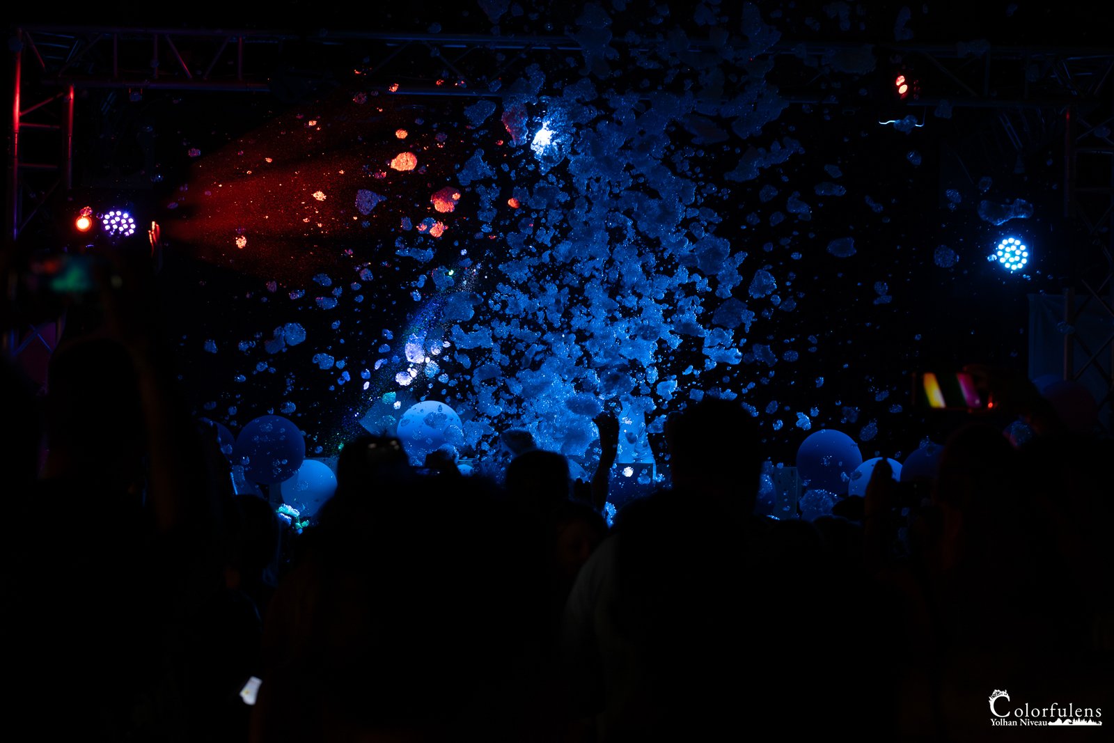 Vue nocturne d'un concert vibrant avec confettis colorés et foule exaltée
