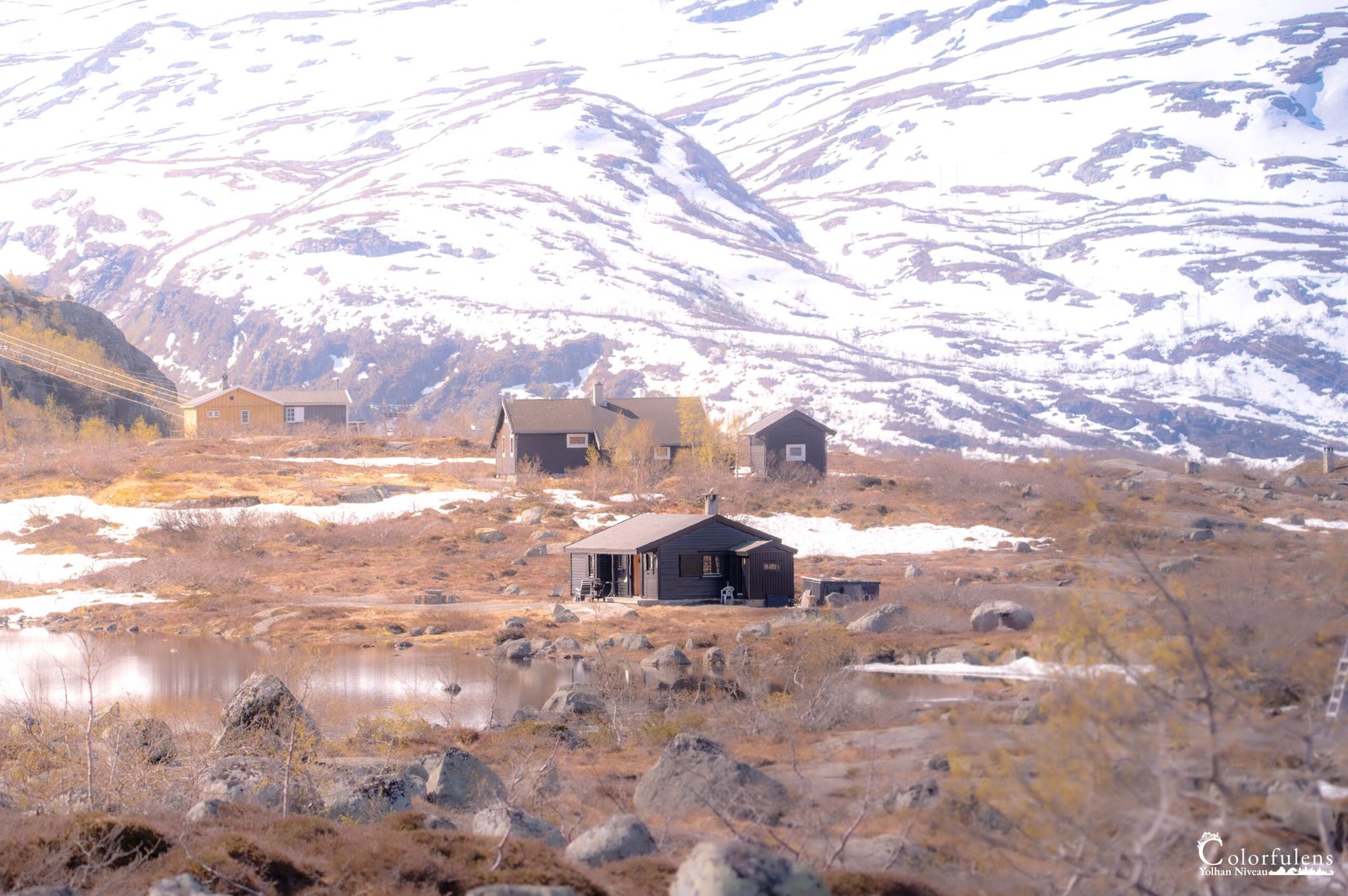 Scène sereine des cabanes montagnardes sous la neige fondante avec reflets printaniers