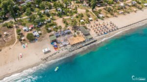 Photographie aérienne d'un camping corse en bord de mer, mettant en avant le calme, la détente et les paysages côtiers avec activités de loisirs.