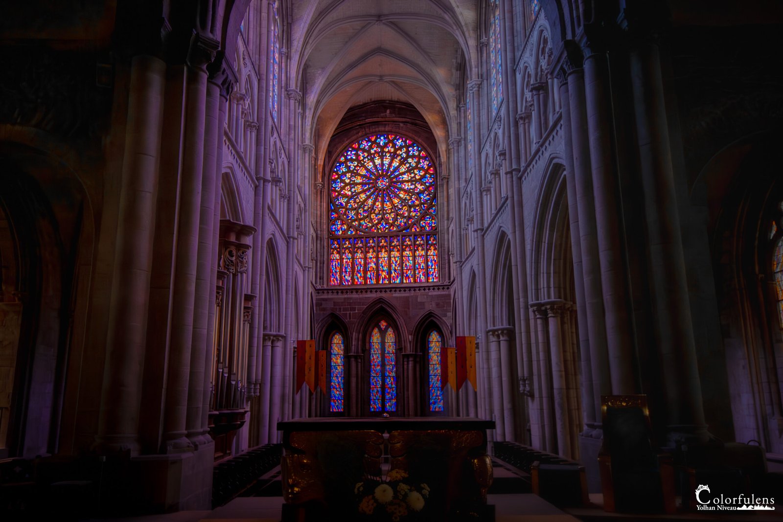 Rosace impressionnante et colorée illuminant l'intérieur gothique de la Cathédrale Saint-Malo, créant un espace empreint de spiritualité et d'histoire.