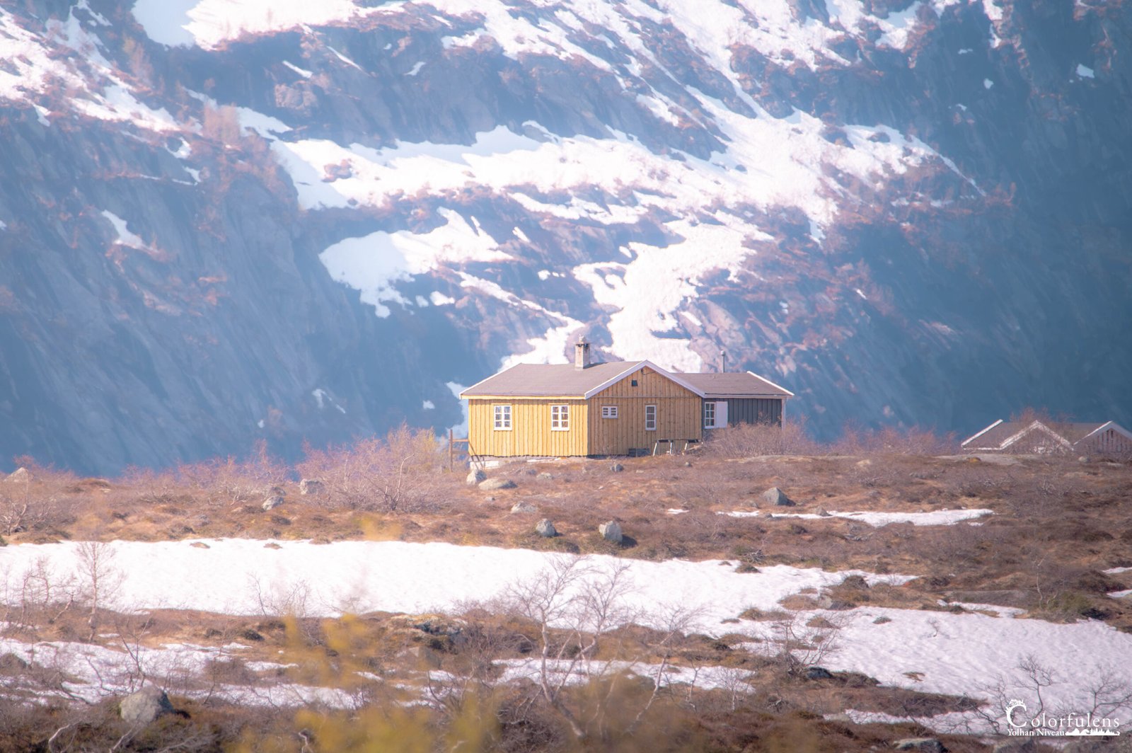 Chalet en bois solitaire au milieu d'un paysage montagneux enneigé, symbole de calme et sérénité, parfait pour une retraite paisible.