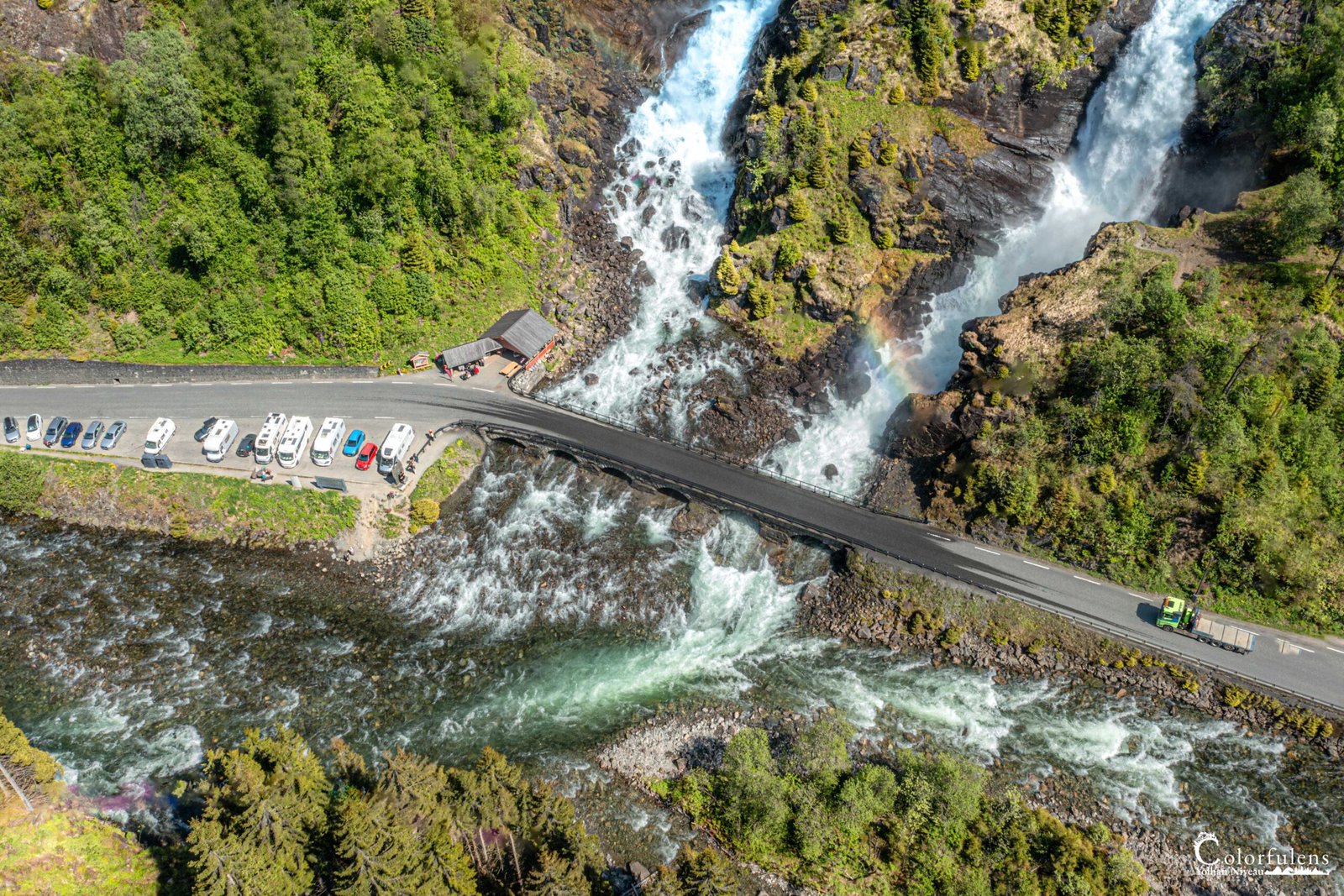 Vue aérienne des majestueuses cascades de Latefossen en Norvège, entourées d'une forêt luxuriante, avec un pont reliant ses rives.