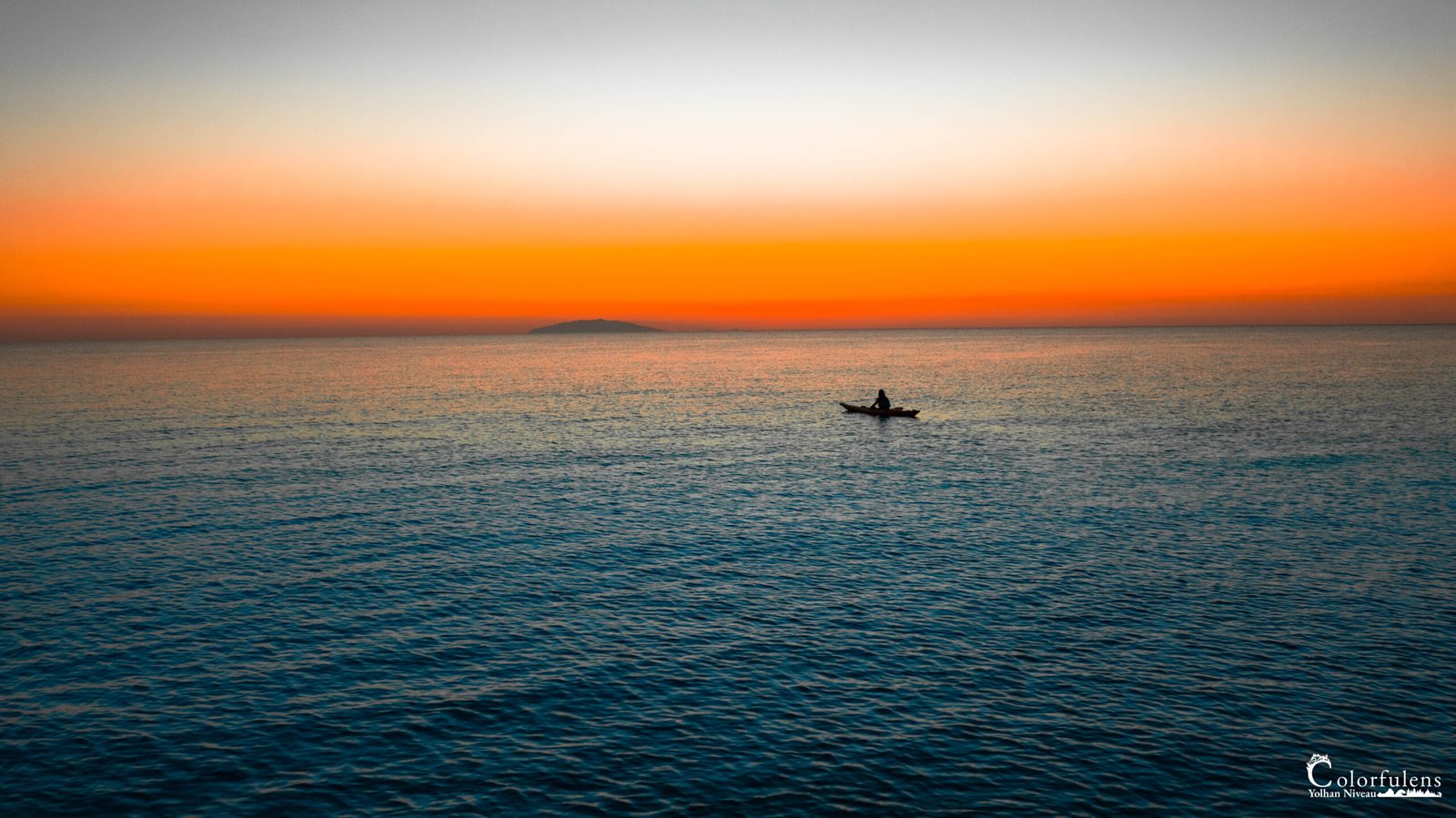 Un pêcheur en parfaite harmonie avec l'océan, capturé dans un moment de tranquillité absolue, le ciel se parant de teintes vespérales apaisantes.