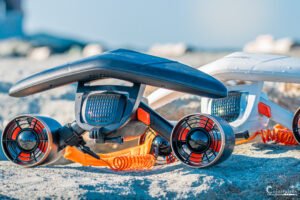 Drone innovant posé sur une plage de sable grossier, prêt pour le prochain vol. Ce contraste entre technologie avancée et décor naturel évoque exploration et innovation.