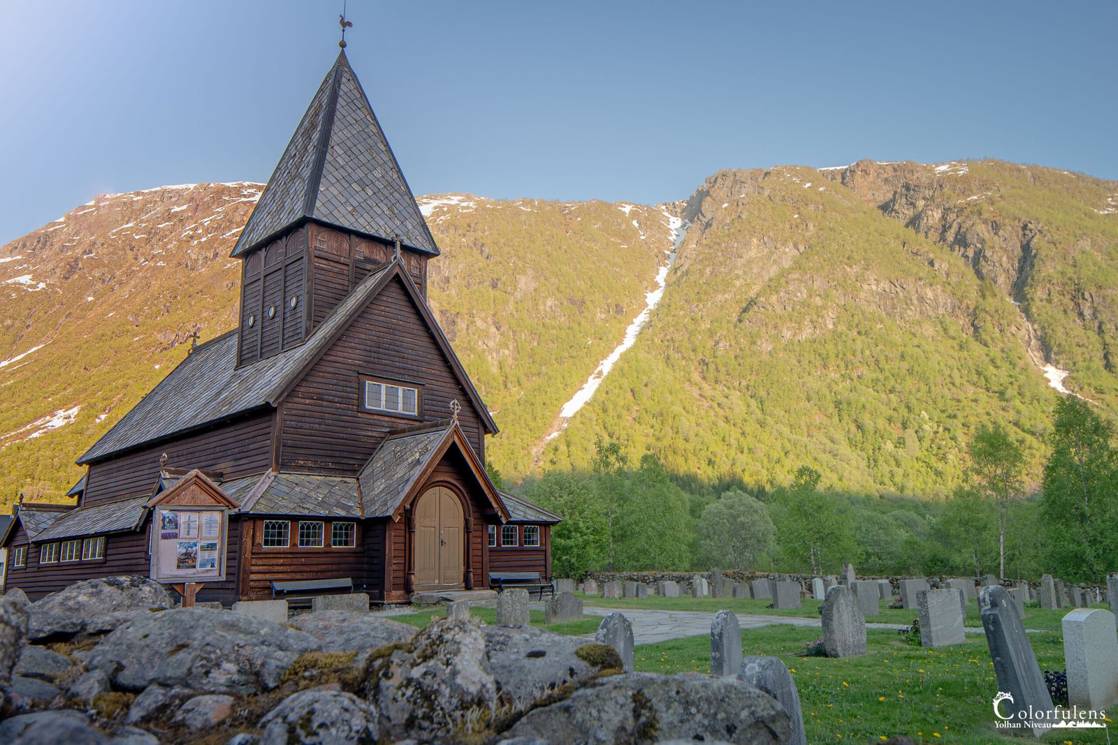Chapelle en bois de la vallée de Røldal, entourée de montagnes, illustrant la spiritualité et l'histoire