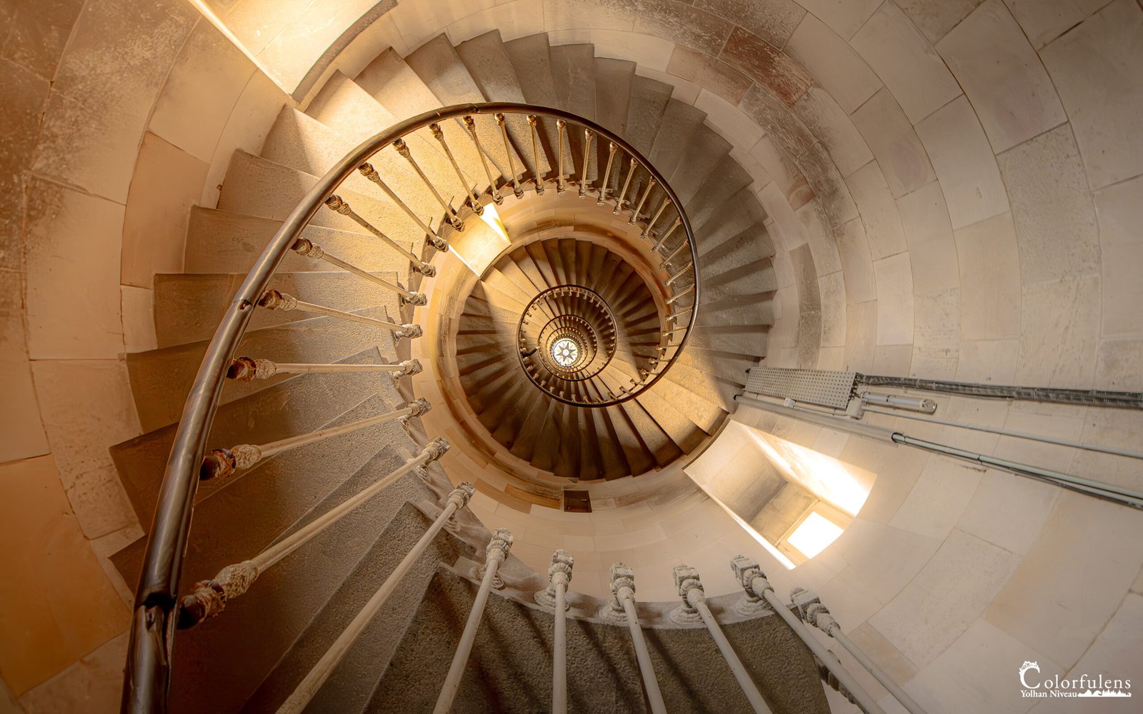 Escalier en colimaçon éclairé dans un phare, symbolisant l'ascension vers la lumière et la connaissance