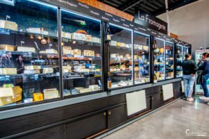 Vitrine réfrigérée de fromages fins et de vins dans une fromagerie de luxe