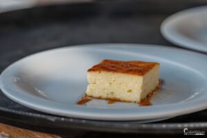 Un gâteau au caramel gourmand, doré et caramélisé, sur une élégante assiette blanche attire l'œil par son apparence appétissante, symbolisant la pâtisserie française raffinée.