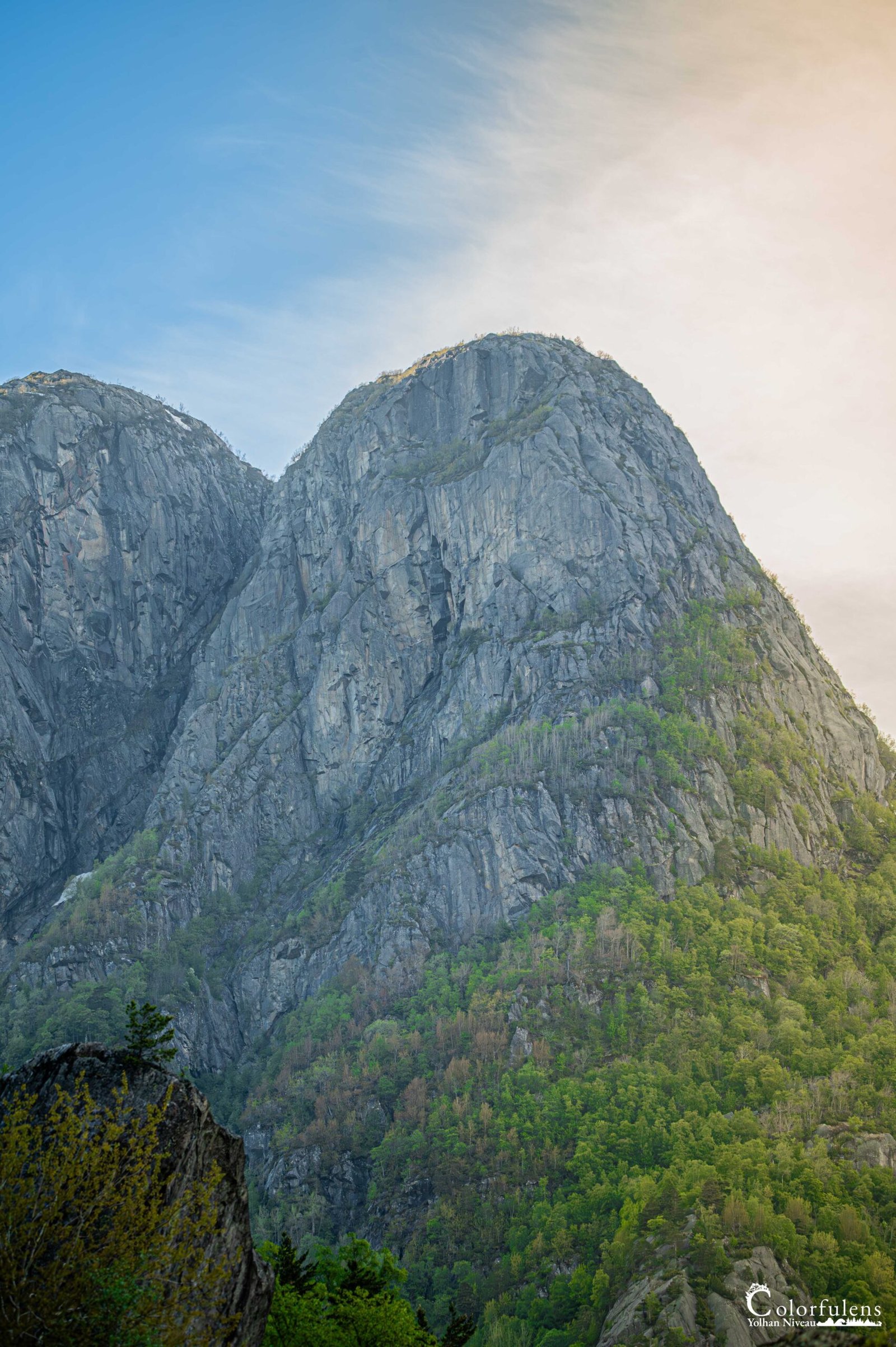 Lumière matinale illuminant les montagnes rocheuses, soulignant la verdure et révélant la beauté naturelle à l'aube.