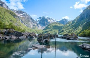 Image d'un lac tranquille avec reflets cristallins des montagnes, évoquant pureté et quiétude.