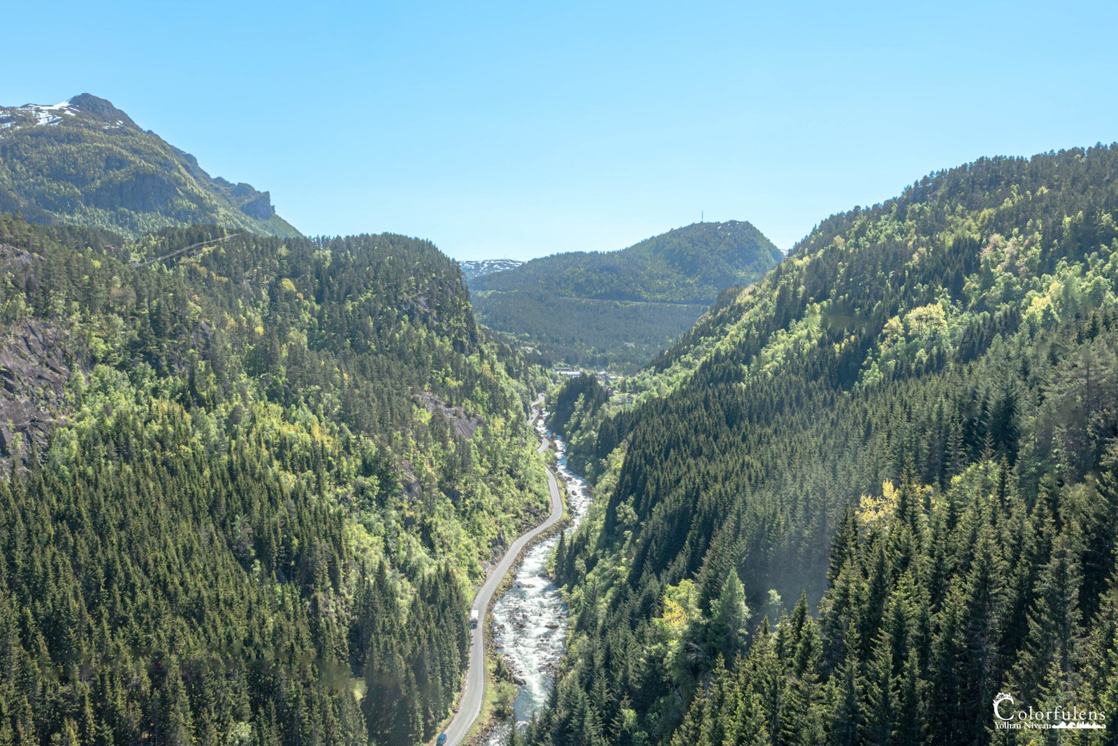 Image captivante d'une vallée boisée traversée par une rivière sinueuse, encadrée par des montagnes, parfaite pour l'évasion et la découverte de paysages naturels.