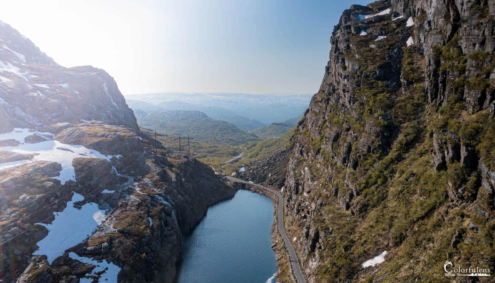 Paysage spectaculaire de Vestland avec un fjord étincelant sous le soleil, entouré de majestueuses montagnes rocheuses et d'eau calme reflétant le ciel.