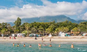 Vacanciers profitant de la plage au camping Merendella en Corse, entre montagne et mer.