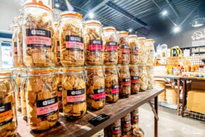 Présentation alléchante de bocaux en verre remplis de biscuits artisanaux dans une biscuiterie moderne et authentique.