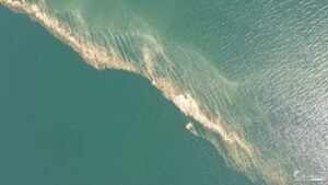 Une image apaisante montrant un sillage étincelant sur l'eau, offrant une réflexion harmonieuse entre le mouvement humain et la tranquillité naturelle.