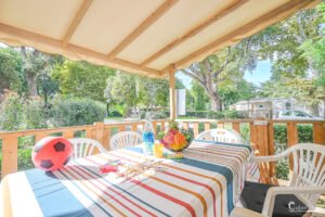 Terrasse en bois dans un camping corse, ambiance détendue, idéale pour des vacances familiales relaxantes