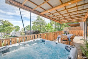 Terrasse en bois avec jacuzzi et table extérieure, offrant une détente inégalée au Camping Merendella, cadre idéal pour se ressourcer