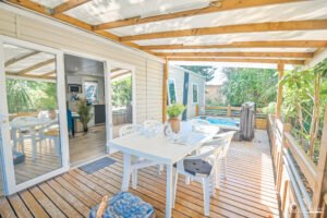 Ambiance de vacances au camping Merendella en Corse, avec terrasse et jacuzzi pour moments de détente sous le soleil.