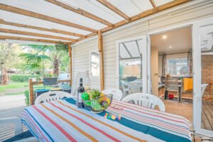 Terrasse de mobil-home au camping Merendella en Corse, offrant un cadre de détente avec mobilier accueillant, décoration colorée, et atmosphère de convivialité corse.