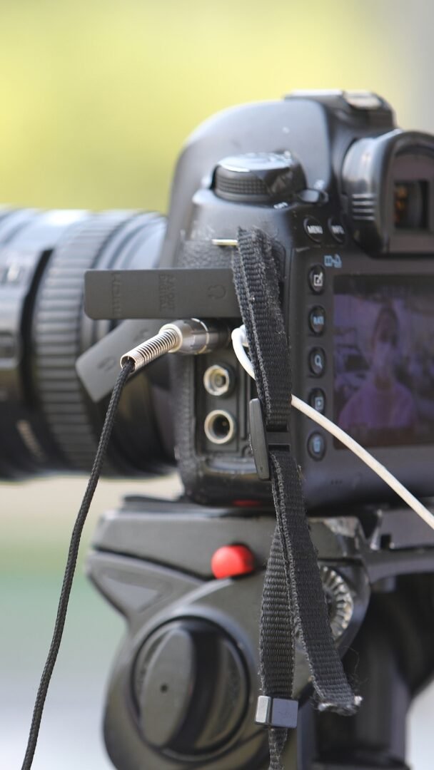 Photographie d'un appareil photo canon avec un bokeh et un naturel vert. La photographie montre les boutons de réglage et des connecteurs ajouter à l'appareil photo.