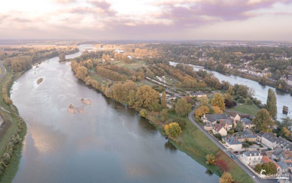 Vue aérienne d'Amboise en automne, montrant la majesté de la Loire entourée de couleurs chaudes et dorées.