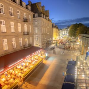 Une soirée animée à Saint-Malo avec des terrasses éclairées et des bâtiments historiques