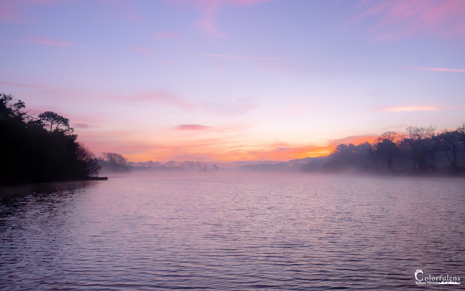 Lever de soleil magique sur l'étang de Noyalo, où la brume matinale danse au-dessus des eaux paisibles, créant une ambiance surréaliste et poétique.