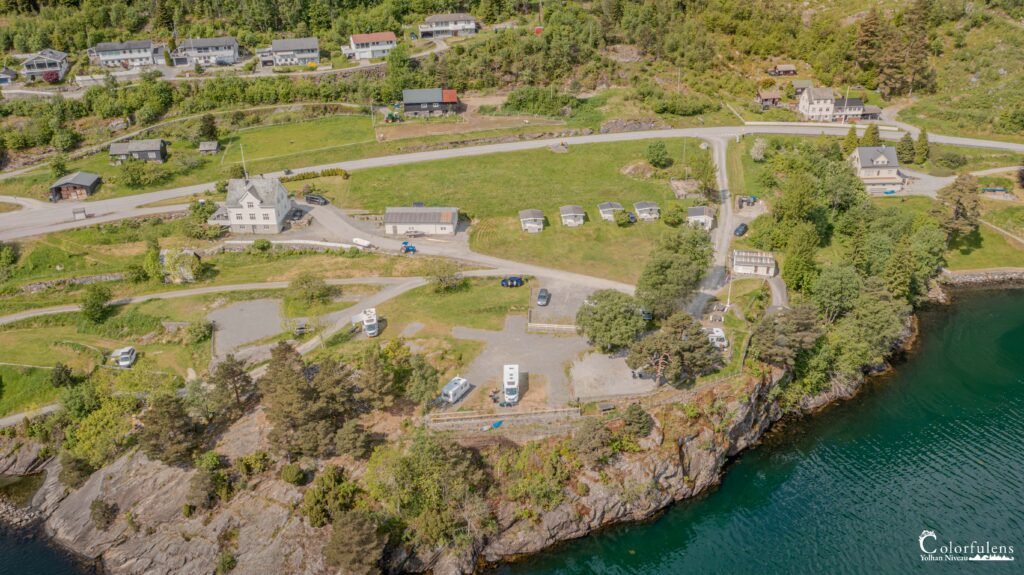 Camping idyllique en Norvège avec ses eaux cristallines, ses maisons pittoresques et une nature verdoyante, offrant une évasion parfaite.