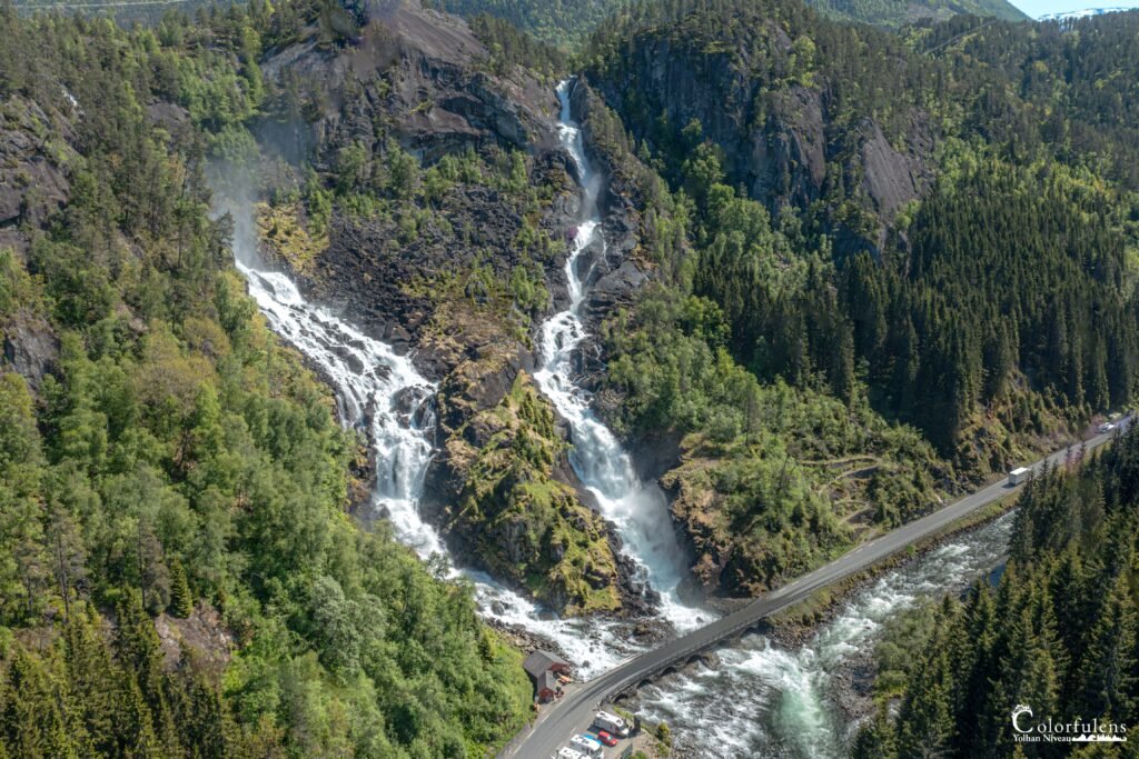 Cascade majestueuse entourée de forêt verdoyante, offrant sérénité et grandeur naturelle.