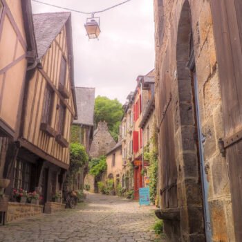 Une charmante scène médiévale à Dinan, révélant des maisons en colombage colorées et des pavés anciens qui reflètent l'héritage breton.