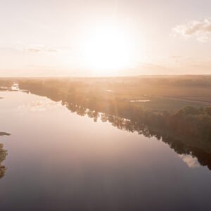 Coucher de soleil sur la Loire dévoilant des reflets dorés sur l'eau, créant une scène paisible et harmonieuse.