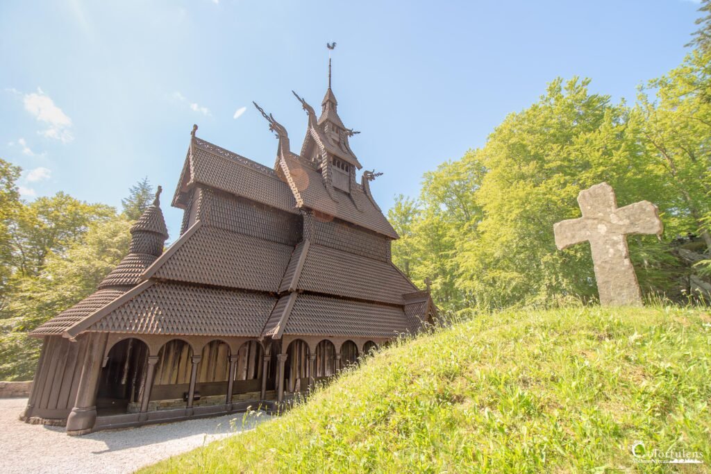 Église en bois debout de Bergen, illustrant l'architecture traditionnelle norvégienne, avec un ciel bleu en arrière-plan.