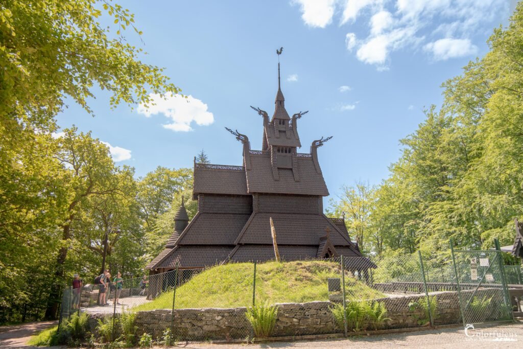 Photographie d'une église en bois debout à Bergen, symbole de l'architecture traditionnelle norvégienne, illuminée par le soleil avec un ciel dégagé.