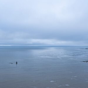 Paysage marin à la Plage de Betahon, une brume douce flotte au-dessus des eaux calmes, créant une ambiance sereine et invitante. Découvrez la tranquillité captivante de la nature.