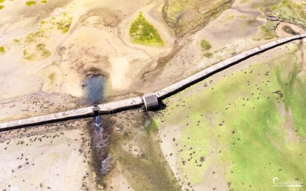 Photographie aérienne époustouflante du Moulin à Marée de Berno sur l'île d'Arz, illustrant l'harmonie entre patrimoine historique et paysage marin en Bretagne.