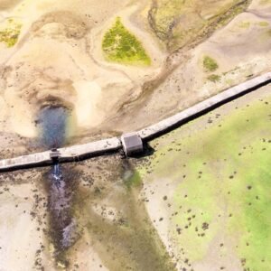 Photographie aérienne époustouflante du Moulin à Marée de Berno sur l'île d'Arz, illustrant l'harmonie entre patrimoine historique et paysage marin en Bretagne.