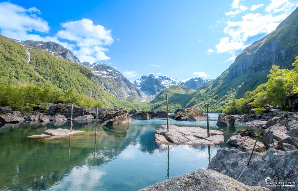 Paysage de montagne paisible avec lac calme, reflets de ciel bleu et sommets enneigés