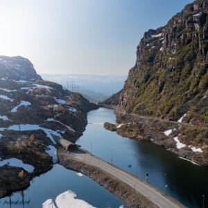 Route sinueuse de Vestland entre montagnes, rivière et tunnel, capturant l'harmonie de la nature et de l'ingénierie