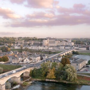 Vue aérienne d'Amboise au coucher de soleil, avec le Château d'Amboise surplombant la Loire et le pont en arche, unissant histoire et nature.