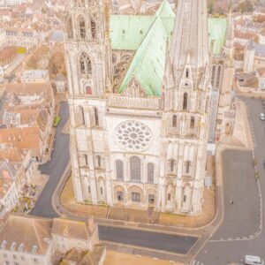 Vue aérienne saisissante de la Cathédrale de Chartres, mettant en lumière l'architecture gothique et le charme de l'ancien avec les toits et la structure historique.