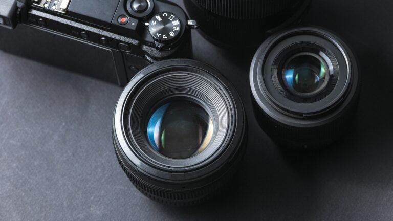 Appareil photo numérique avec objectifs Canon et Nikon posés sur une surface, illustrant la passion des photographes pour leurs outils.